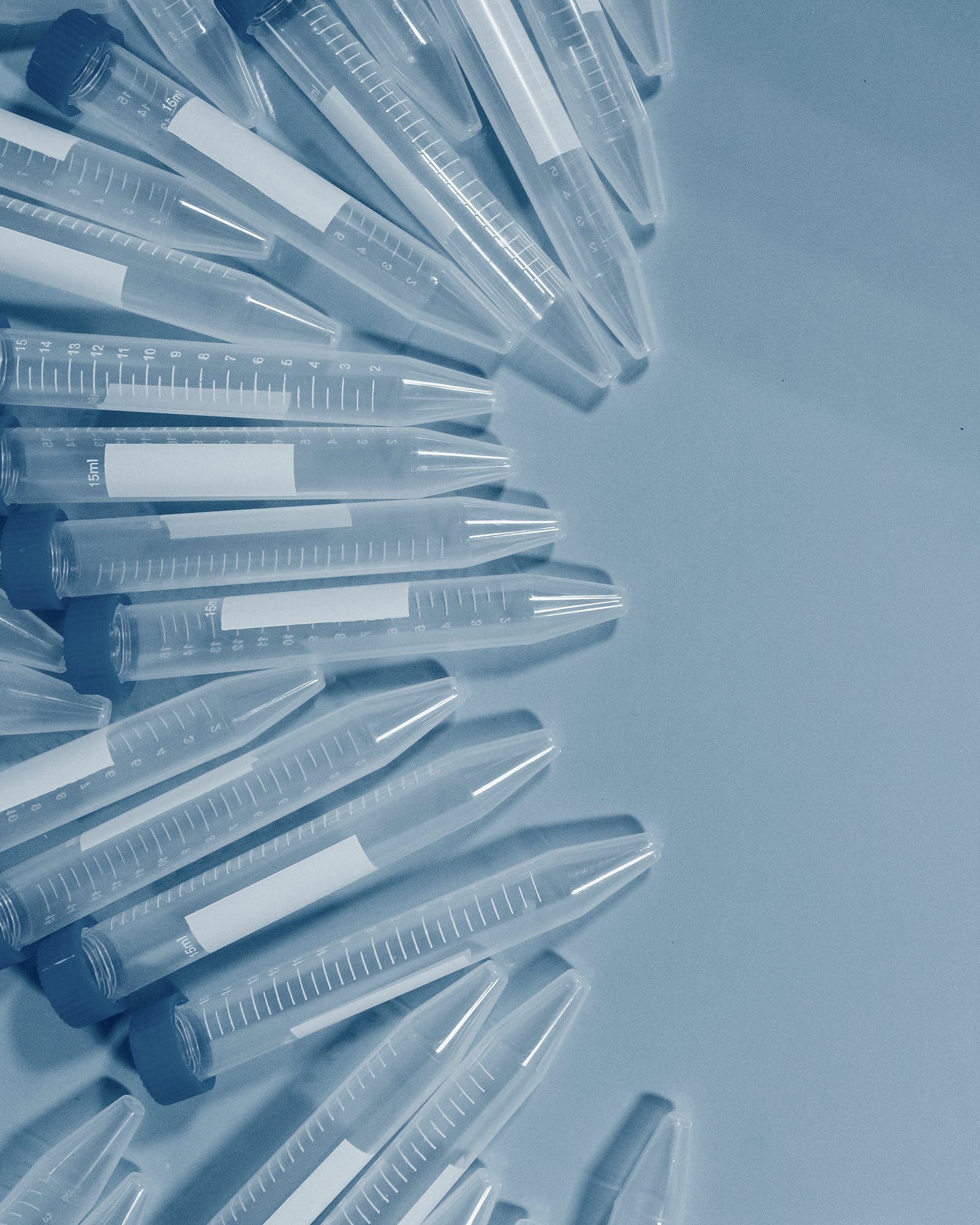 Blue-capped laboratory tubes fanned across a cold blue surface